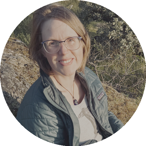 Portrait of Anne-Lynn sitting on a hillside overlooking a lake